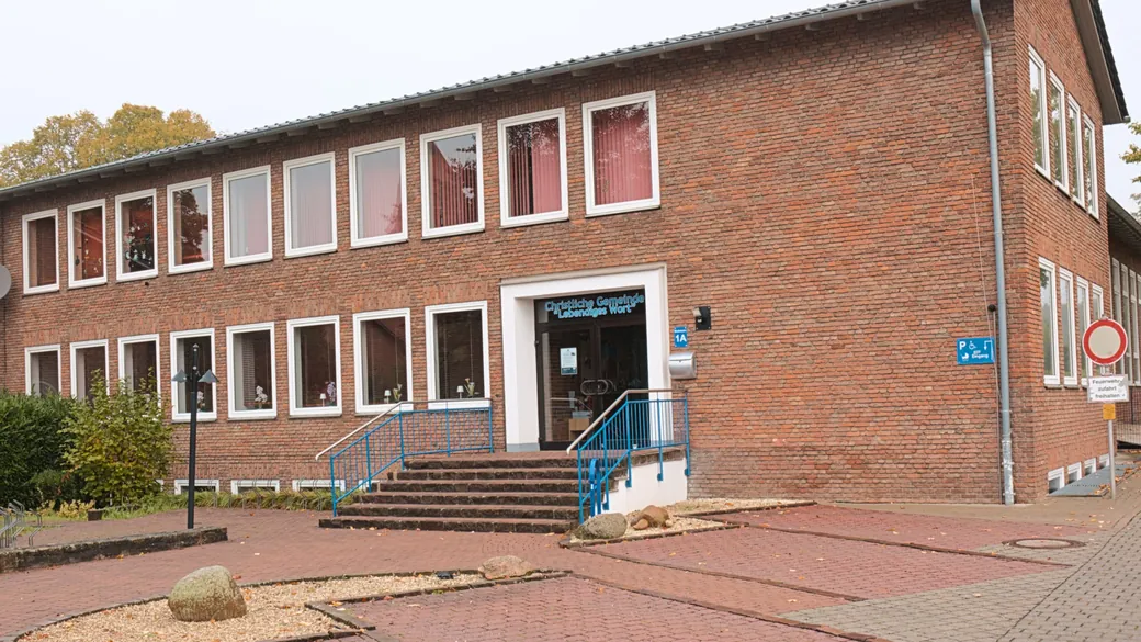 Das Gemeindehaus der Christlichen Gemeinde Lebendiges Wort in der Brahmsstraße 1a: rotes Backsteingebäude, Eingang mit Treppe und blauem Geländer